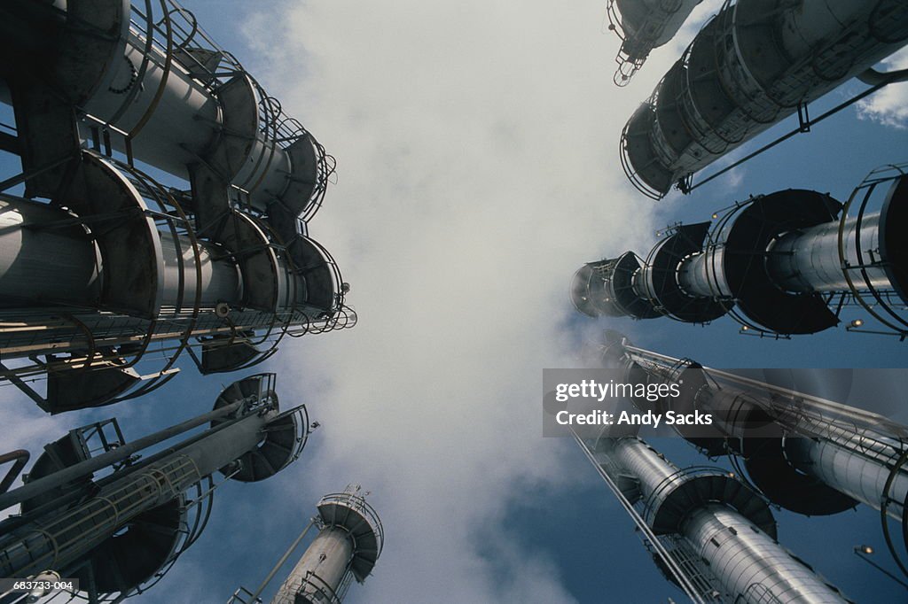 Oil refinery,low angle view of stacks emitting smoke