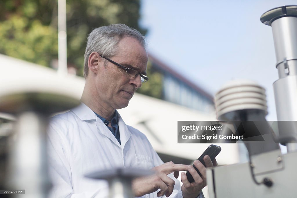 Meteorologists Male Male Meteorologist Texting On Smartphone At Outdoor Weather Station ...