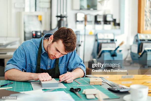 young craftsman using scalpel and making work in print studio - esterilla para cortar fotografías e imágenes de stock