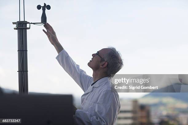 male meteorologist measuring wind using anemometer at weather station - weather station fotografías e imágenes de stock