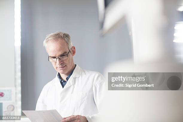 male meteorologist reading data in weather station laboratory - forecast accuracy stock pictures, royalty-free photos & images