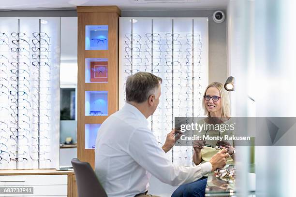 patient consultation at small business opticians - opticien stockfoto's en -beelden