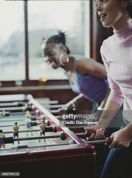 two young women playing table football - girls' night in stock pictures, royalty-free photos & images