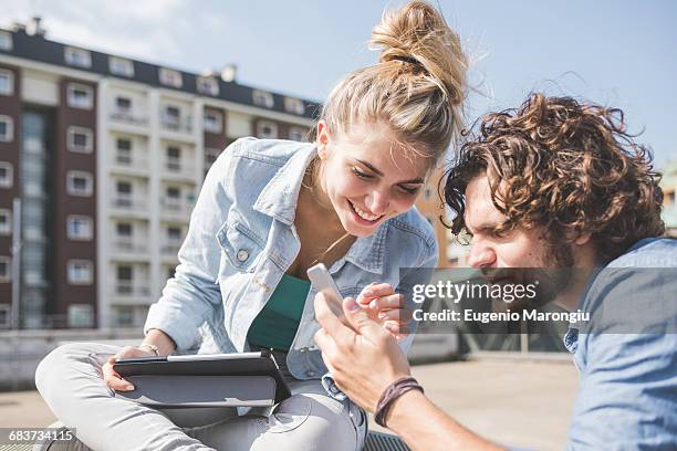 friends on social media outdoors - man lady phone ipad outside stock pictures, royalty-free photos & images