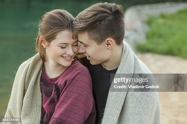 happy loving couple wrapped in blanket resting by lake - voronezh stock pictures, royalty-free photos & images