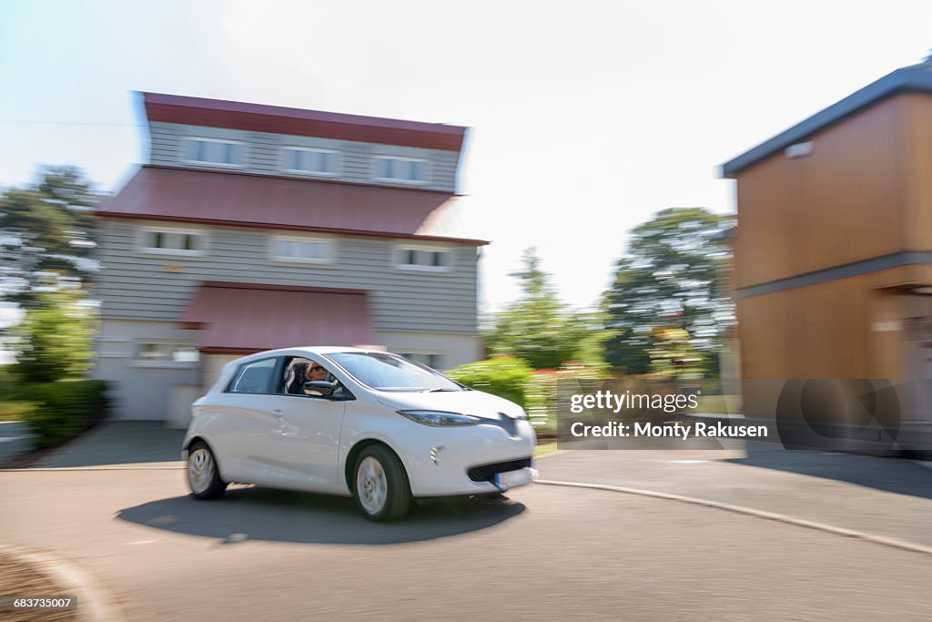 Electric car driving through neighbourhood