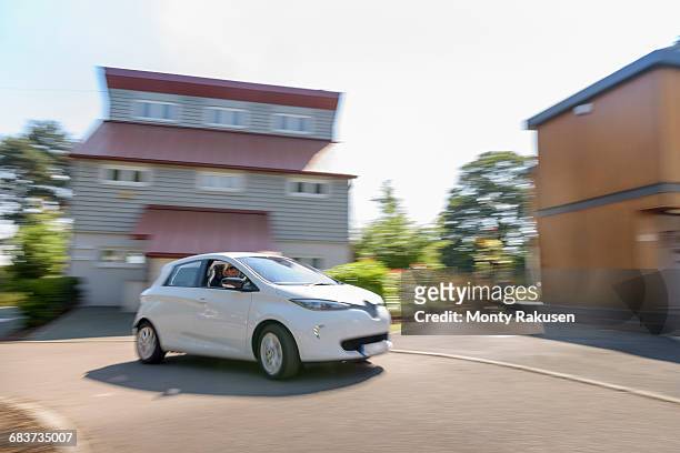 electric car driving through neighbourhood - rijden een motorvoertuig besturen stockfoto's en -beelden
