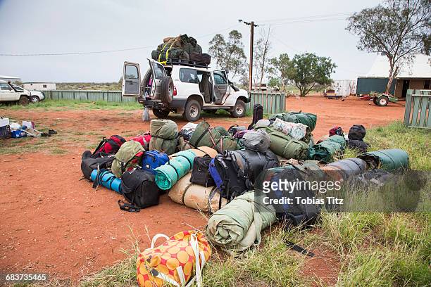 heap of luggage on field by car against clear sky - car camping luggage photos et images de collection