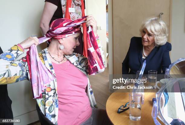 Camilla, Duchess of Cornwall is shown how to tie a headscarf by cancer patient Tracy Jameson during a visit to Maggie's Oxford to see how the Centre...