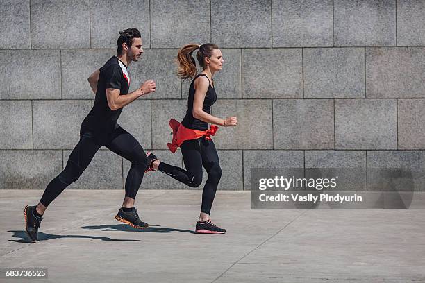 side view of people jogging on sidewalk by wall - running man profile stock pictures, royalty-free photos & images