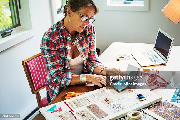 a woman creating a collage picture with material and paper. - moodboard stock pictures, royalty-free photos & images