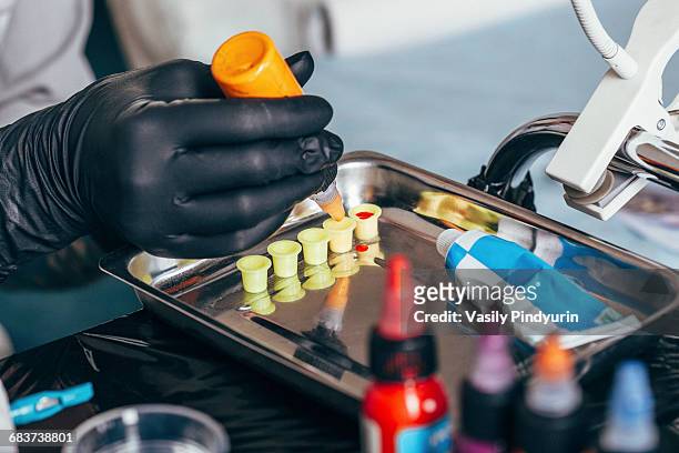 cropped image of tattoo artist filling ink in containers at art studio - art studio stock pictures, royalty-free photos & images