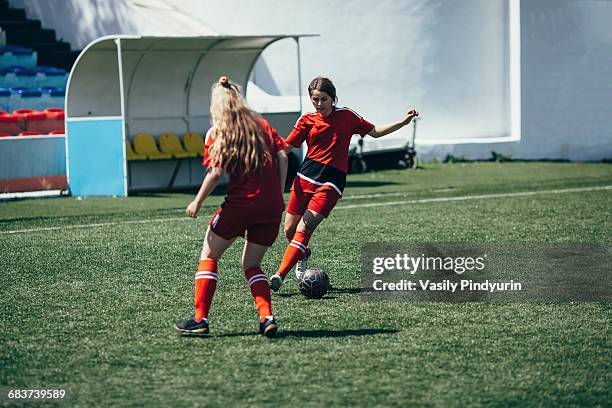 Determined teenagers playing soccer on field