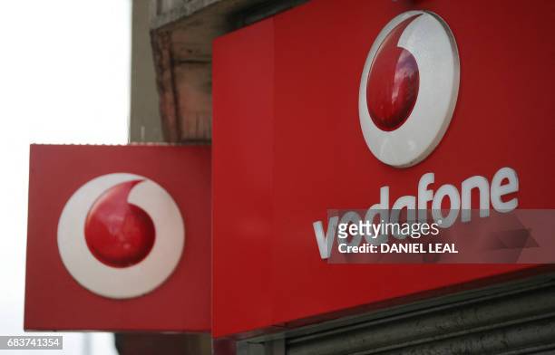 Vodafone logo is seen at a store in central London on May 16, 2017. - Vodafone logged today a large annual net loss after slashing the value of its...