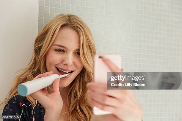 woman brushing teeth, taking selfie - brush teeth phone stock-fotos und bilder