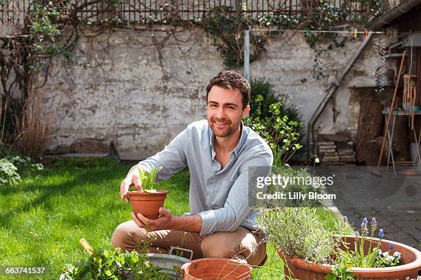man in garden tending to plants - green fingers - fotografias e filmes do acervo
