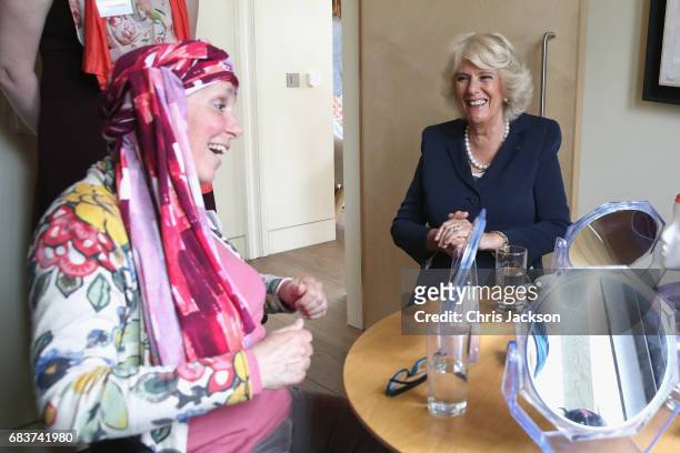 Camilla, Duchess of Cornwall is shown how to tie a headscarf by cancer patient Tracy Jameson during a visit to Maggie's Oxford to see how the Centre...