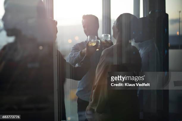 group of businesspeople having friday night drinks - back lit window stock pictures, royalty-free photos & images