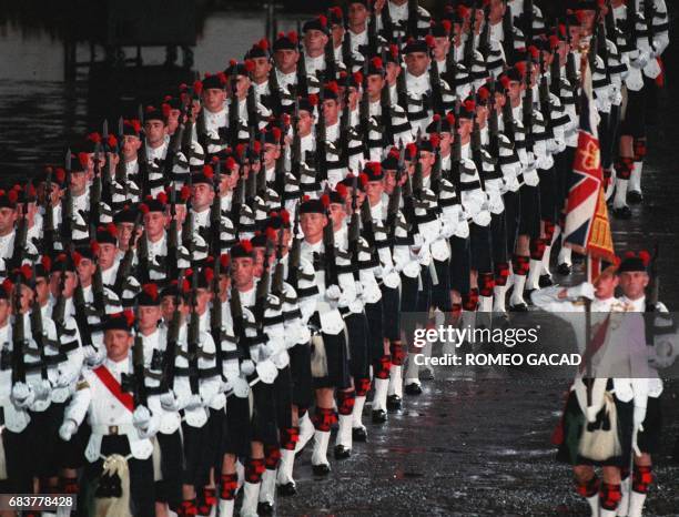 Soldiers participate in a military parade as part of handover ceremonies at HMS Tamar military base 30 June. The event was attended by outgoing...