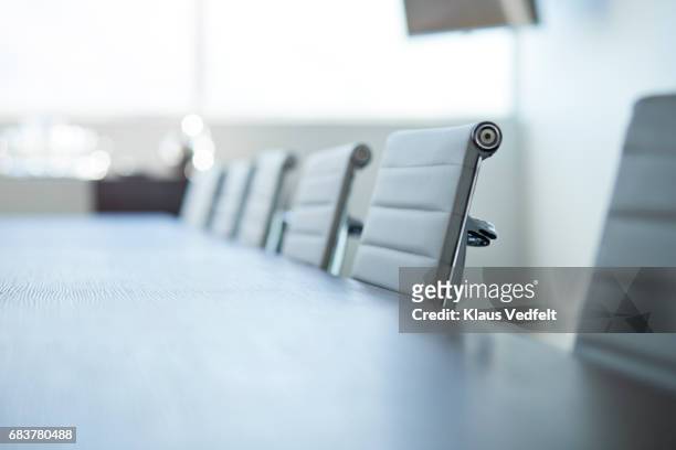 row of empty chairs in board room - konferenzraum stock-fotos und bilder