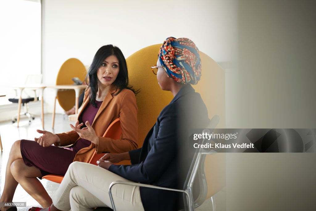 Co-workers talking together at office space