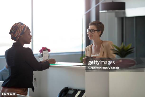 businesspeople checking in to hotel in the lobby - reception stock-fotos und bilder