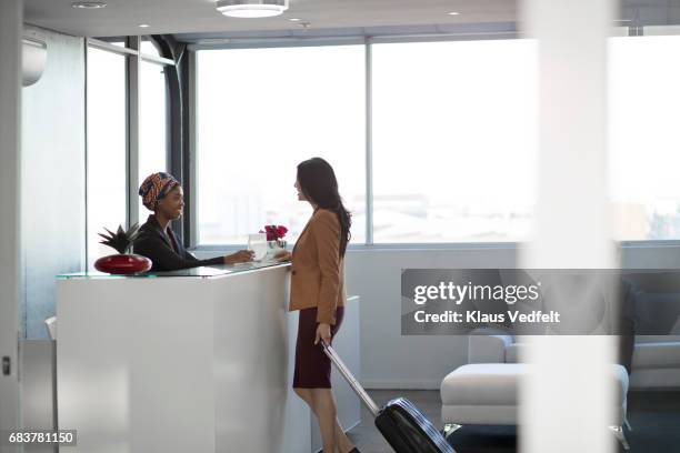 businesspeople checking in to hotel in the lobby - diversity showcase arrivals stock pictures, royalty-free photos & images