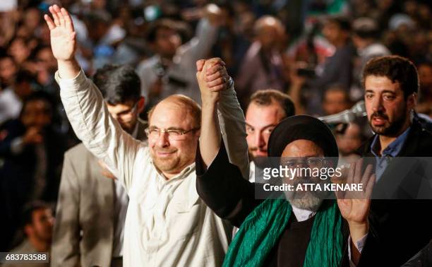 Iranian presidential candidate Ebrahim Raisi holds hands with former presidential candidate and mayor of Tehran, Mohammad Bagher Ghalibaf , as he...