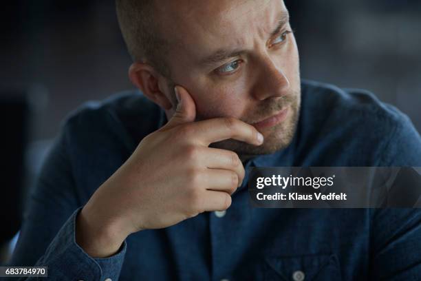 businessman sitting in conference room, looking thoughtful - man hand on chin stock pictures, royalty-free photos & images