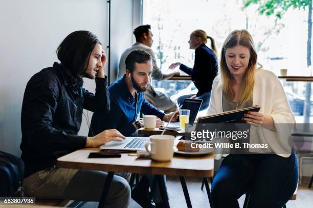 Colleagues Sitting Down, Working In A Business Cafe