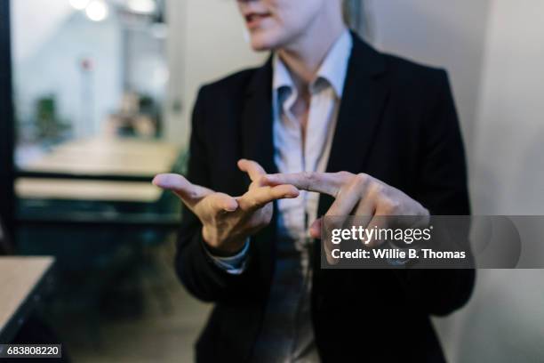 businesswoman illustrating points at a meeting - gesturing 個照片及圖片檔