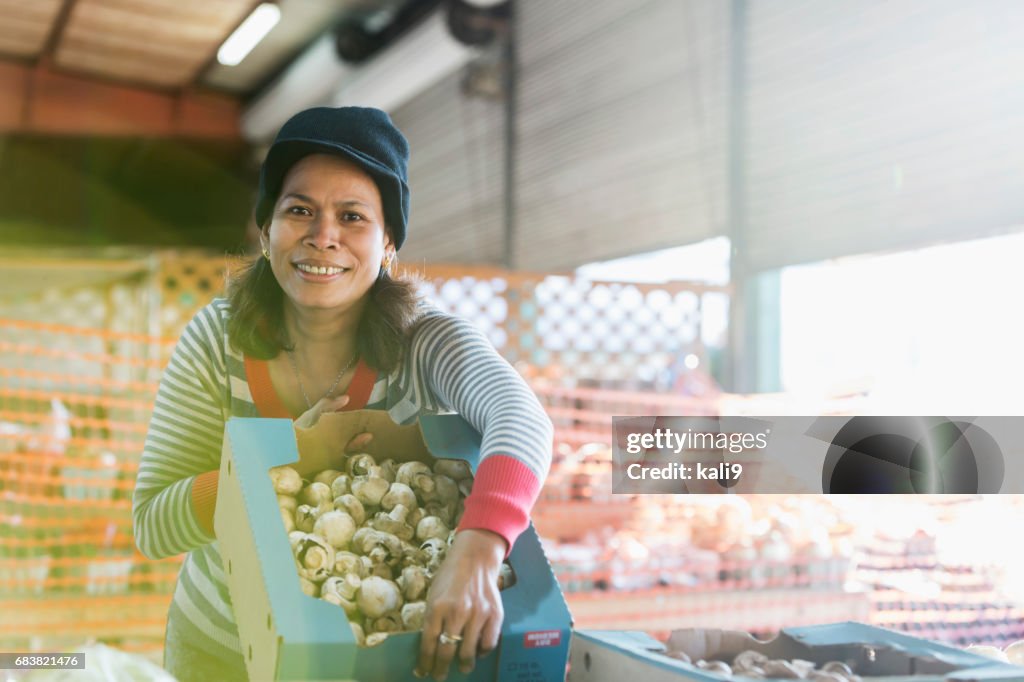 Asian woman working at produce stand