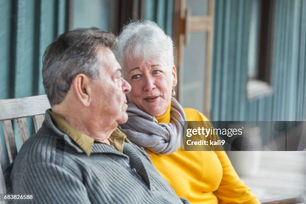 ernsthafte älteres paar sprechen auf veranda - two people talking face to face stock-fotos und bilder