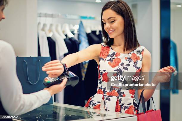 girl is paying using her smart watch in the mall - smartwatch pay stock pictures, royalty-free photos & images