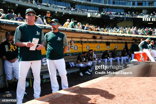 Manager Bob Melvin and Bench Coach Mark Kotsay of the Oakland Athletics stand in the dugout during the game against the Seattle Mariners at the...