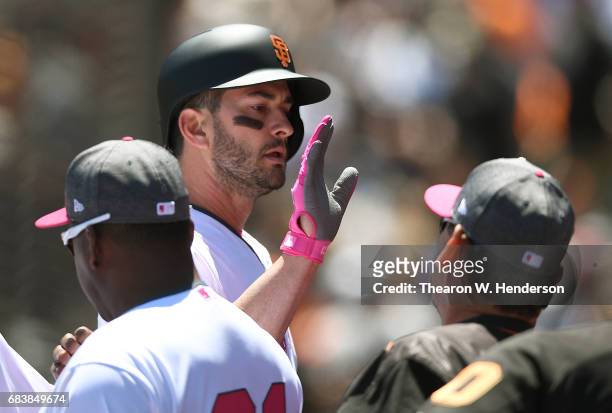 Justin Ruggiano of the San Francisco Giants is congratulated by coaches and teammates after hitting a solo home run against the Cincinnati Reds in...