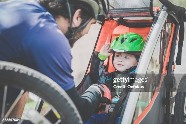 millennial parents father biking with toddler - vehicle trailer stock pictures, royalty-free photos & images