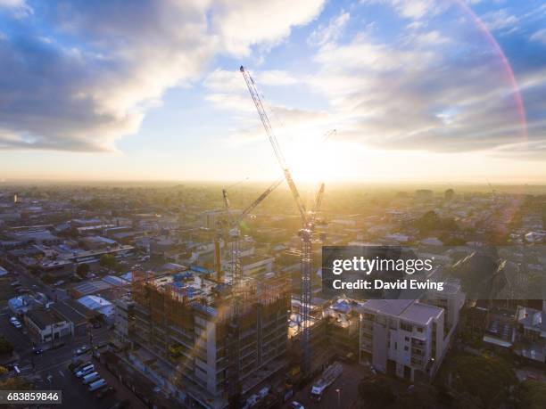 cranes tower over a new construction site at sunrise in brunswick, melbourne. - housing development stock pictures, royalty-free photos & images