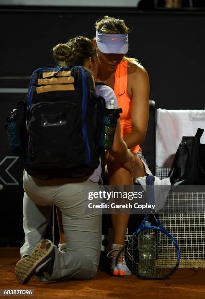 Maria Sharapova of Russia recieves treatment after pulling up with an injury during her second round match against Miriana Lucic-Baroni of Croatia in...