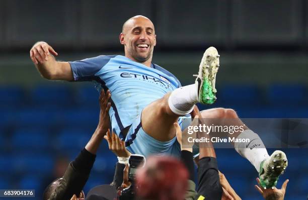 Pablo Zabaleta of Manchester City is thrown into the air by his Manchester City team mates after the Premier League match between Manchester City and...