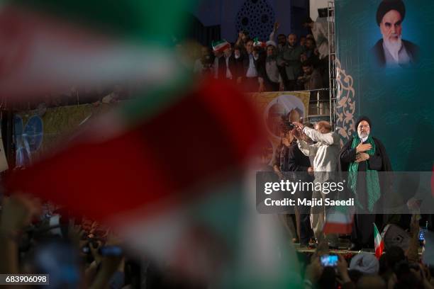 Iranian presidential candidate Ebrahim Raisi holds hands with former presidential candidate and mayor of Tehran, Mohammad Bagher Ghalibaf , as he...