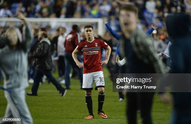 Tom Cairney of Fulham looks dejected as Reading fans invade the pitch in celebration after the Sky Bet Championship Play Off Second Leg match between...