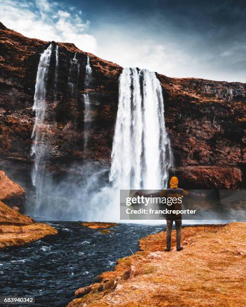 tourist awe at seljalandsfoss waterfall in iceland - gloomy swamp stock pictures, royalty-free photos & images