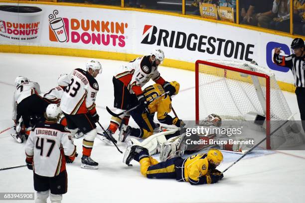 John Gibson of the Anaheim Ducks lies on the ice as he makes a save against Pontus Aberg and Mike Fisher of the Nashville Predators during the first...