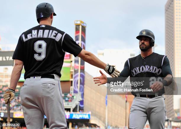LeMahieu of the Colorado Rockies congratulates teammate Ian Desmond on scoring a run against the Minnesota Twins during the second inning of the game...
