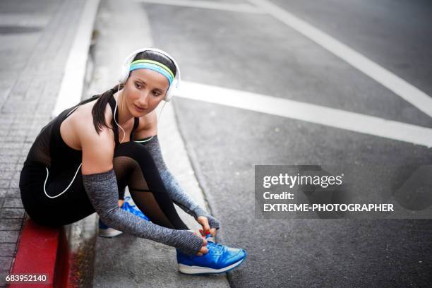female athlete in the city - untied shoelace stock pictures, royalty-free photos & images