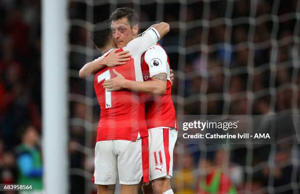 Alexis Sanchez of Arsenal hugs Mesut Ozil of Arsenal during the Premier League match between Arsenal and Sunderland at Emirates Stadium on May 16,...