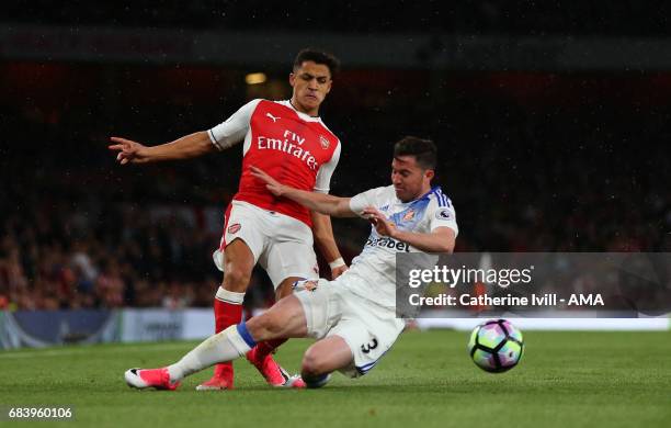 Alexis Sanchez of Arsenal is tackled by Bryan Oviedo of Sunderland during the Premier League match between Arsenal and Sunderland at Emirates Stadium...