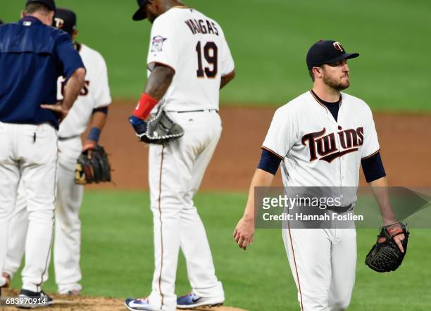 Phil Hughes of the Minnesota Twins walks back to the dugout after being relieved from the game against the Colorado Rockies during the sixth inning...