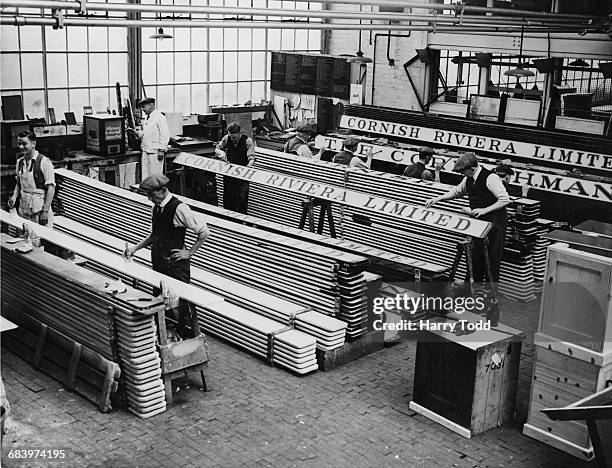Coachbuilders for Great Western Railway at work on painting the roof label boards on the passenger coaches for the two new Cornish Riviera Express...